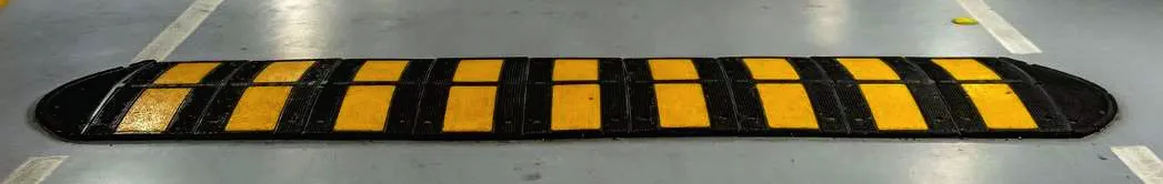 Yellow and black speed breaker installed on a concrete floor